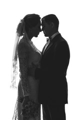 Black and white photo with silhouettes of the bride and groom