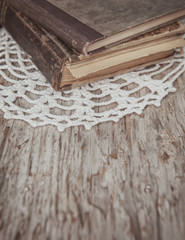 Fototapeta premium Vintage old books and lace fabric on the old wood