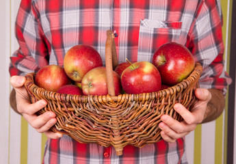 Man holding a basket full of apples