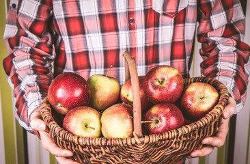 Man holding a basket full of apples