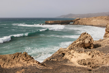 Stormy waves crash against the ochre cliffs of coastline of Atlantic ocean on Fuerteventura island, Canary Islands, Spain