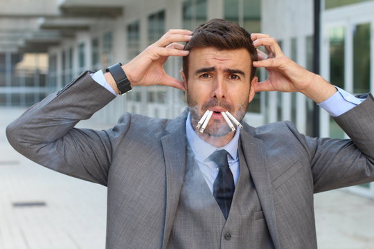 Stressed out businessman smoking four cigarettes at the same time