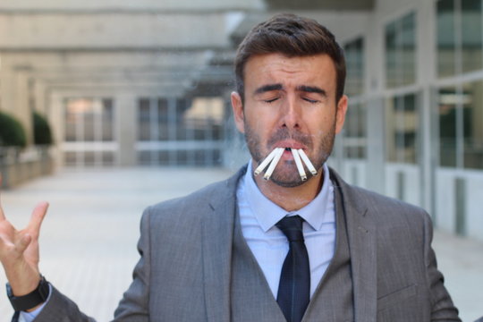 Frustrated businessman showing despair while smoking 