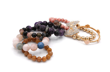 set of lucky stone bracelets and gold one on white background
