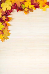Naklejka na ściany i meble Autumn leaves on a wooden background. Space for inscription.