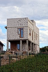 двор с недостроенным домом из белого кирпича на поле в...