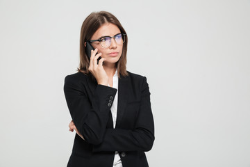 Portrait of a unsatisfied confused businesswoman in eyeglasses and suit