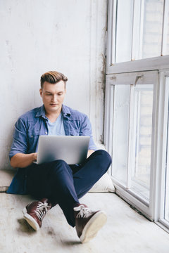 Man working on a laptop on a windowsill