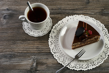Delicious chocolate cake with berries and cup of tea