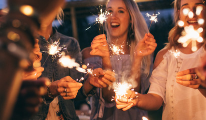 Group of friends enjoying with sparklers in evening