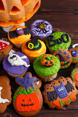 Fototapeta na wymiar Halloween homemade gingerbread cookies and cupcakes background