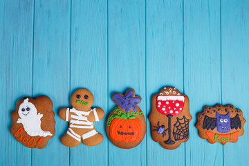 Homemade Halloween ginger cookies with ghosts, pumpkins and bats on bright background, flat lay. Halloween sweets, homemade confectionery, holiday food, trick or treat, free space for text design