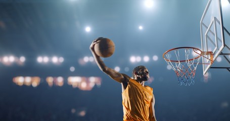 Basketball player performs a slam dunk on a sport background - obrazy, fototapety, plakaty
