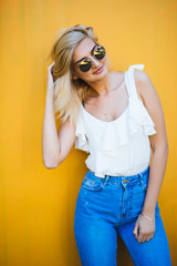 Happy pretty woman in the city, beautiful young girl posing against colorful wall