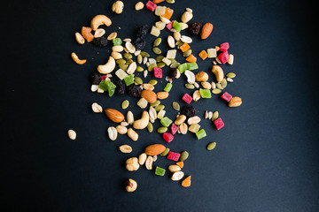 Composition with dried fruits and assorted nuts. Delicacies. Various nuts on stone table. Different kinds of nuts. Close up on a black background. Top view, flat lay. copy space for text