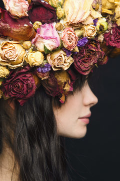 Side view of young woman wearing wreath made of dried flowers