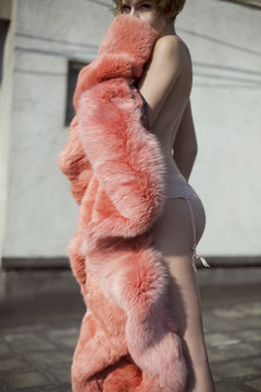 model in underwear posing with peachy fur coat