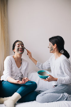 Two female friends having beauty treatment in their home
