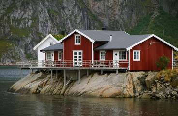 Fototapeta na wymiar Red house on the rock near the water, Lofotens, Norway
