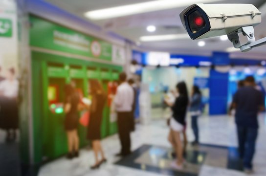 CCTV security indoor camera system operating blurred image of people queuing to withdraw money from ATM (Automated Teller Machine), finance, surveillance security and safety technology concept