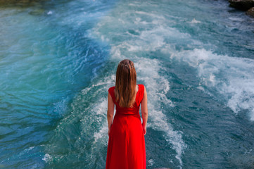 girl stands with his back to the camera. against the background of a beautiful river.