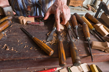 Mano de maestro tallista señalando una gubia.
