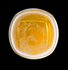 Top view of a glass of beer on black background