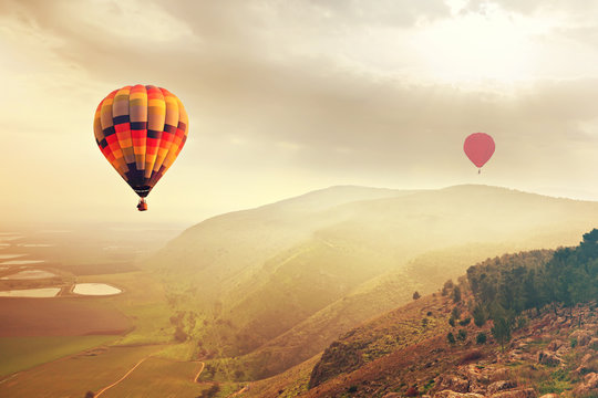 Hot Air balloons in the mist sunlight over the mountains of Mount Gilboa, Israel. Adventure and travel