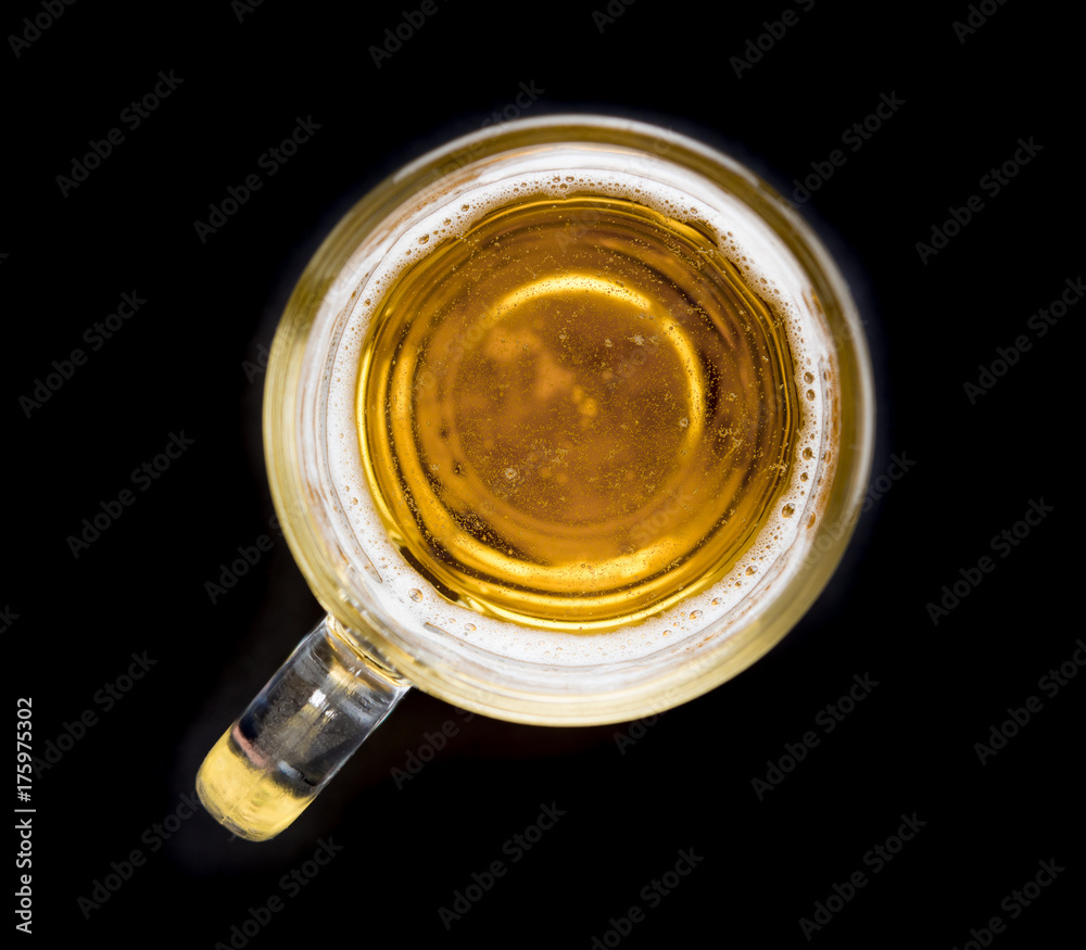 Wall mural top view of a glass of beer on black background