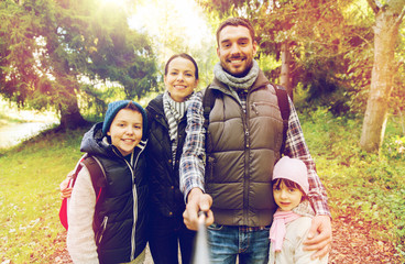 family with backpacks taking selfie and hiking