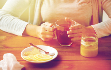 Fototapeta na wymiar close up of woman adding lemon to tea cup