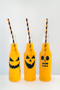 Jack-o'-lantern designs on bottled orange beverage