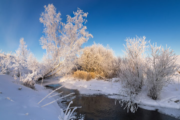 Заснеженный зимний овраг с кустами на берегу ручья, Россия, Урал, январь