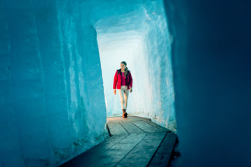 Young Woman Hiking Through Glacier Cave