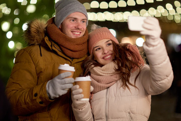 couple with coffee taking selfie at christmas