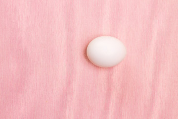 Top view of white egg on the pink background