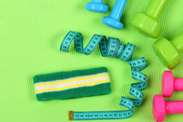 Shaping and fitness equipment. Barbells next to twisted tape measure