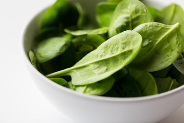 close up of spinach leaves in white bowl