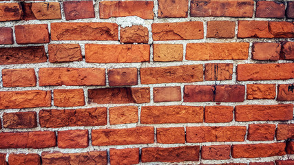 Brick wall made of red stone background. The spoiled brick is vintage.