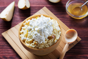 Bowl of millet porridge with cottage cheese and pear