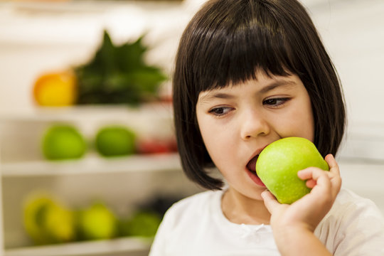 Cute Black Hair Little Girl Eating Green Apple