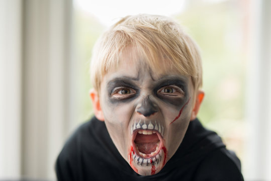 Little Boy With Scary Zombie Ghoul Halloween Costume Make Up Making Scary Face