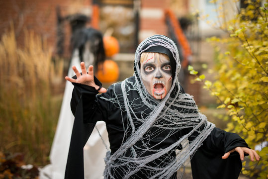 Scary Boy Dressed Up As Zombie Ghoul Halloween Costume Outdoors at House