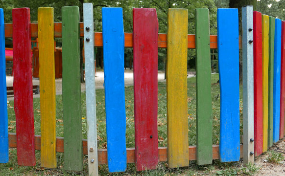 Bunt gestrichener Holz-Lattenzaun in einem Park