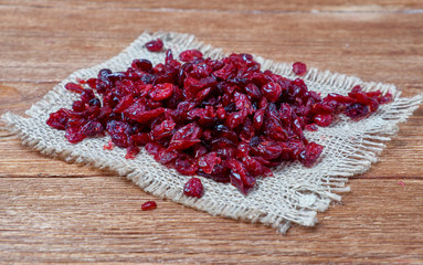 Delicious dried cranberries on rustic wooden background