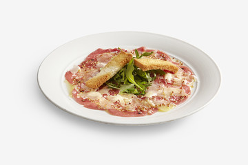Ox carpaccio with toast and wild rocket on white backbround