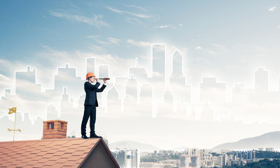 Engineer man standing on roof and looking in spyglass. Mixed med