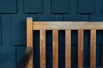 Wooden outdoor bench next to a blue wall