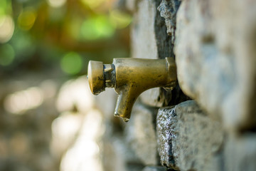 Fuente goteando en muro de piedra