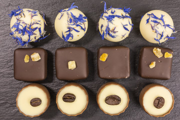 differently decorated white and brown chocolate truffles and pralines